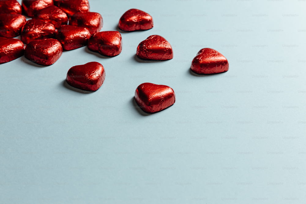 Una pila di cioccolatini rossi a forma di cuore su una superficie blu