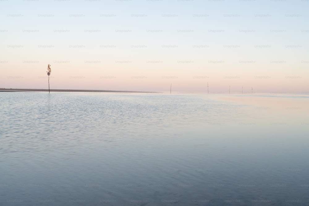 a body of water with a light pole in the distance