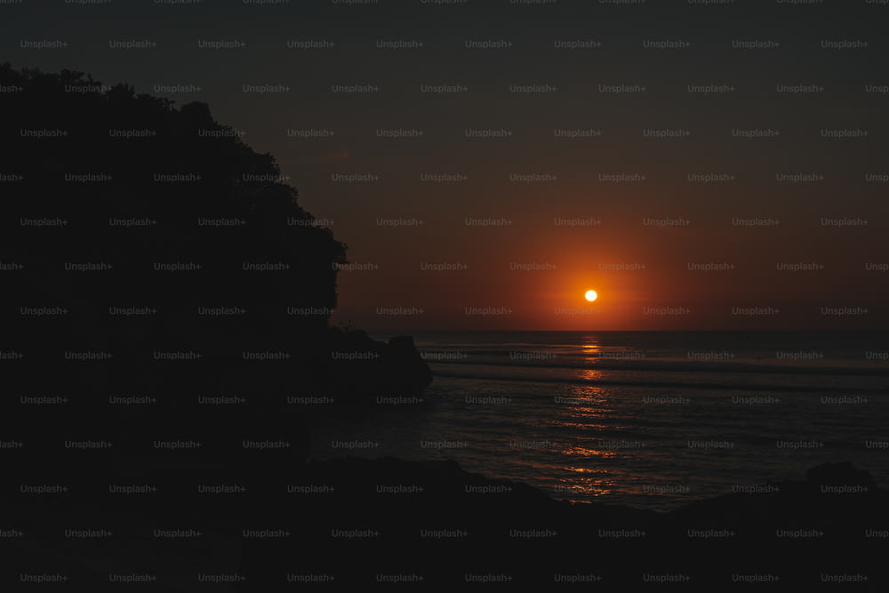El sol se está poniendo sobre el océano visto desde un acantilado
