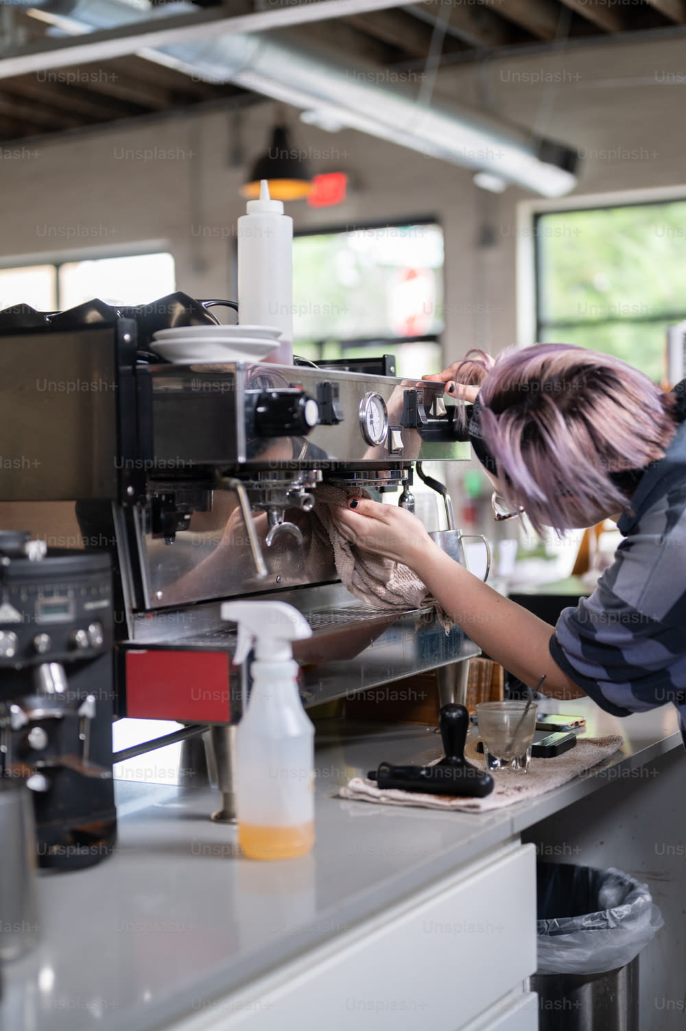 女性がコーヒーマシンで働いています
