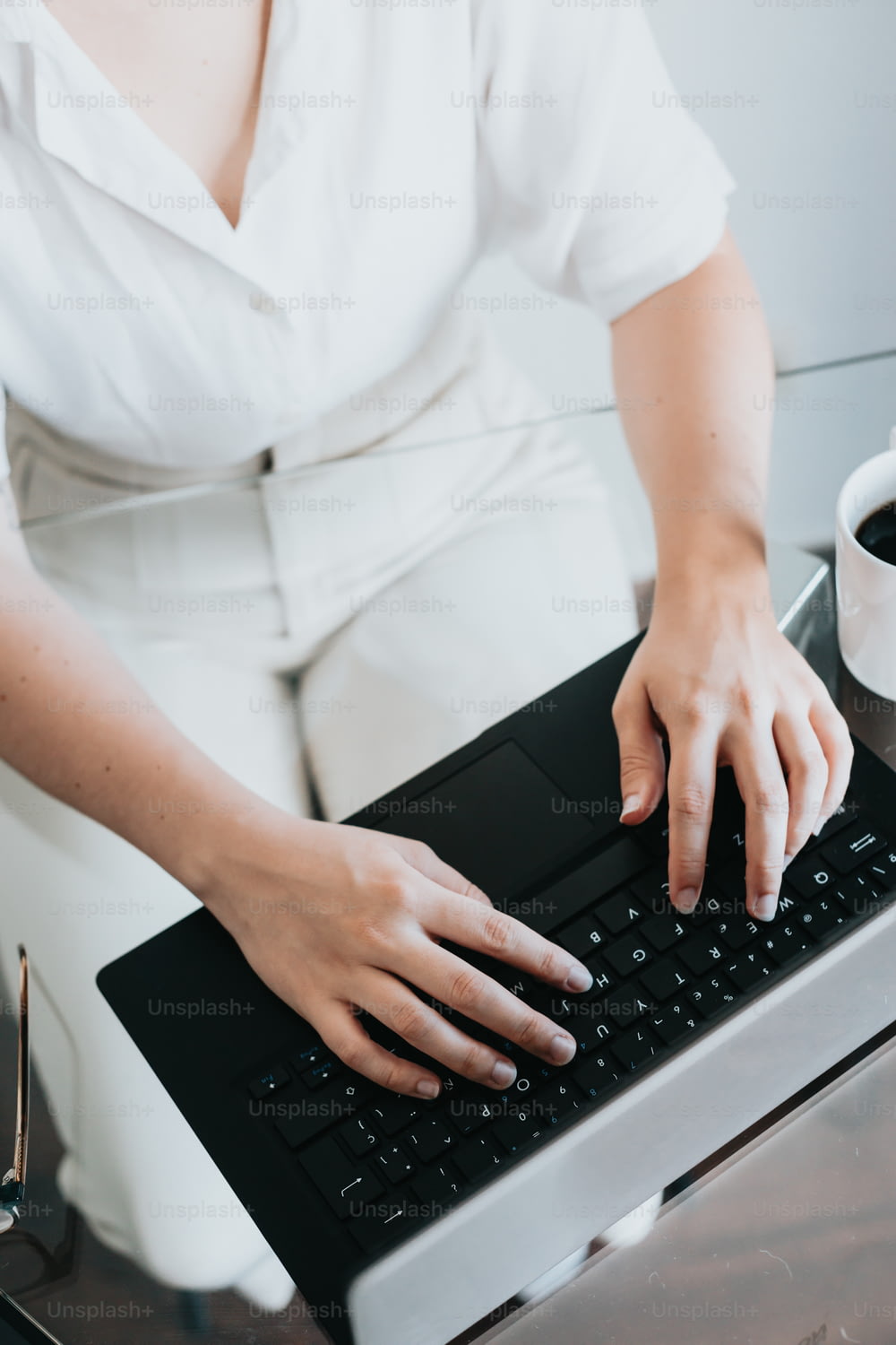 Una mujer está escribiendo en el teclado de una computadora
