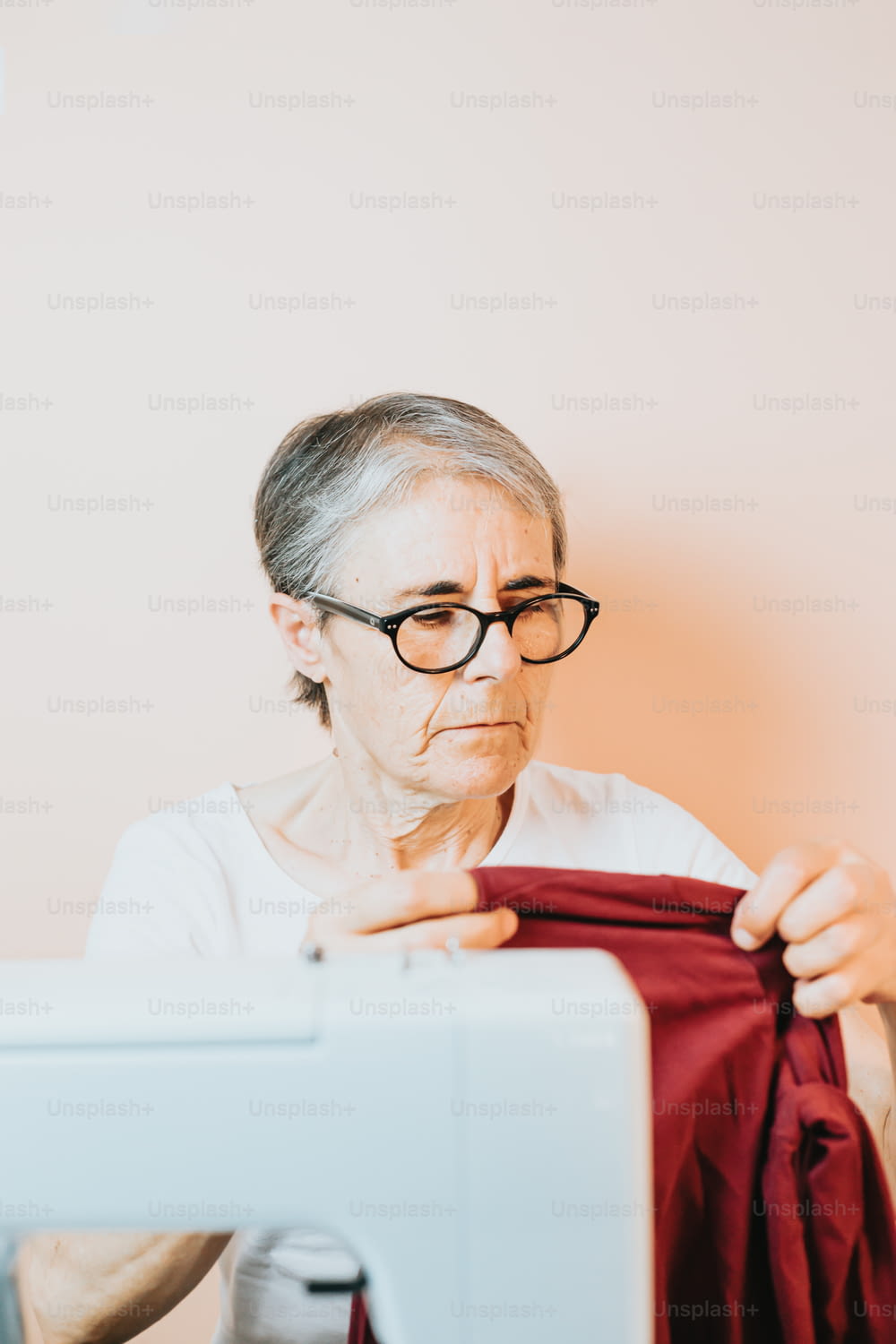 年配の女性がミシンで縫っている