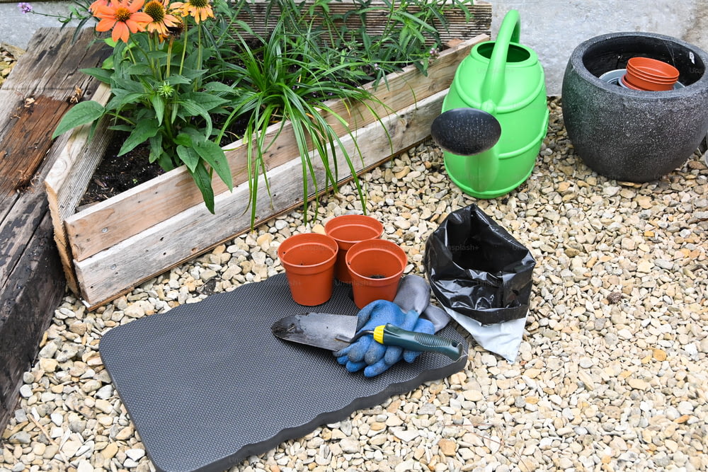a garden with pots and gardening tools on the ground