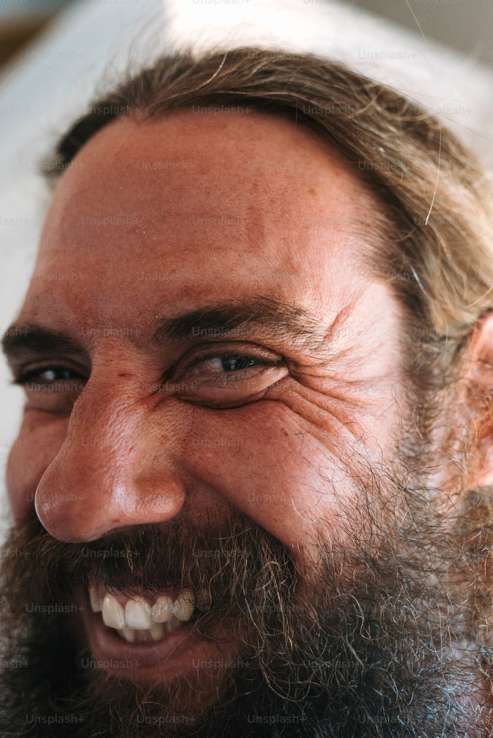 Un primer plano de un hombre con barba sonriendo