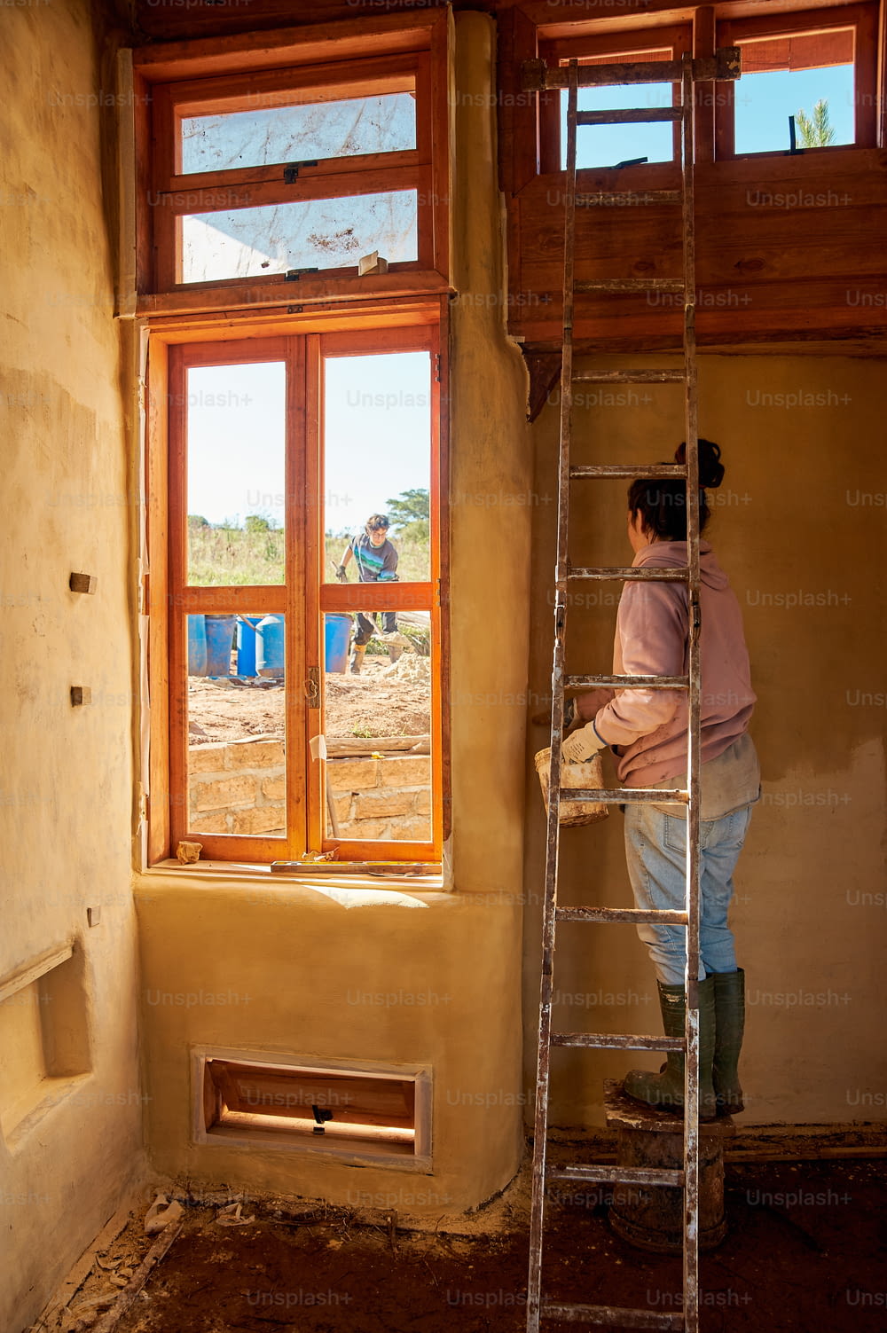 uma mulher em pé em uma escada em frente a uma janela