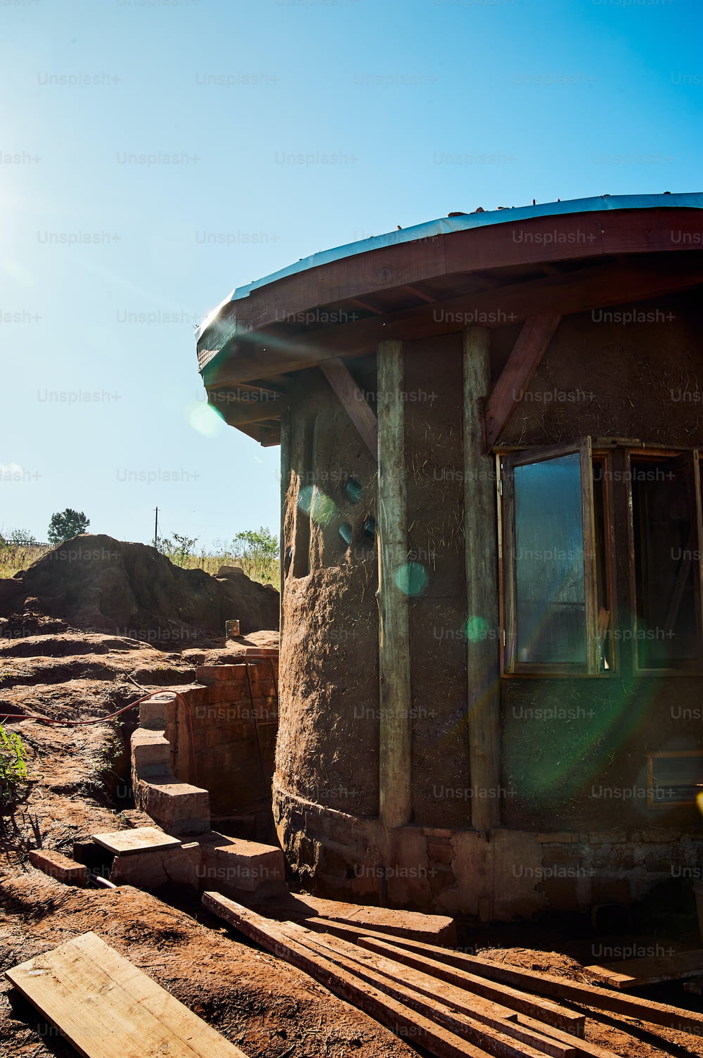 a round building sitting on top of a dirt field
