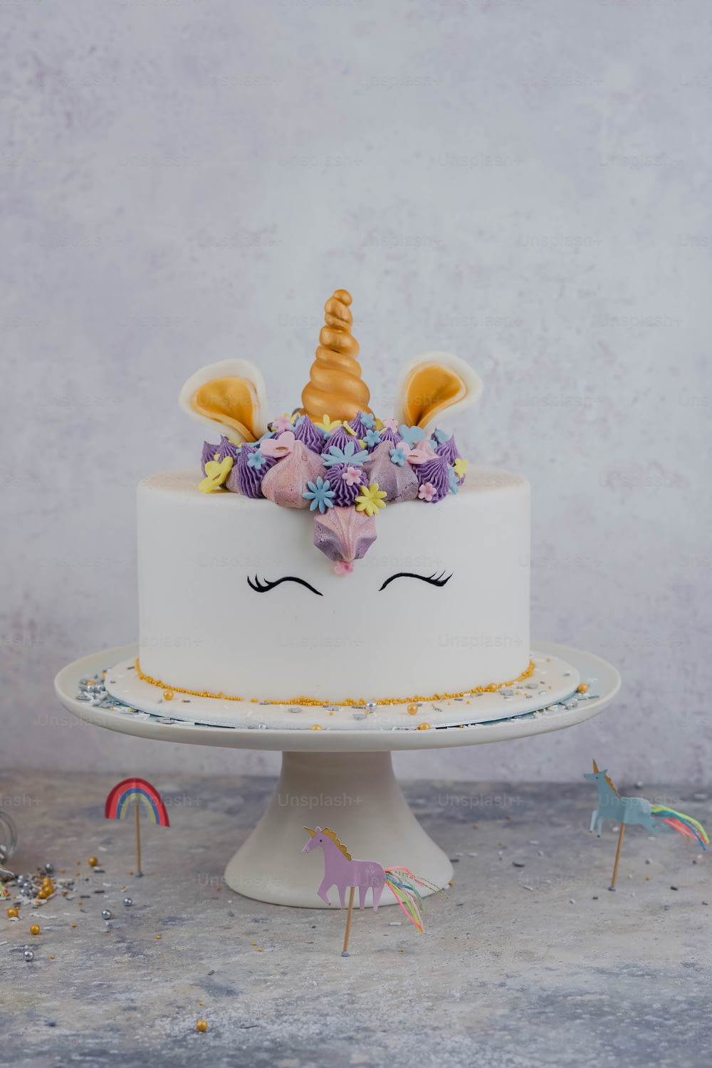 Un pastel blanco con una cara de unicornio encima.