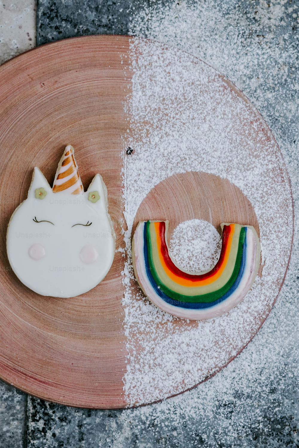 a plate with a unicorn cookie and a rainbow cookie
