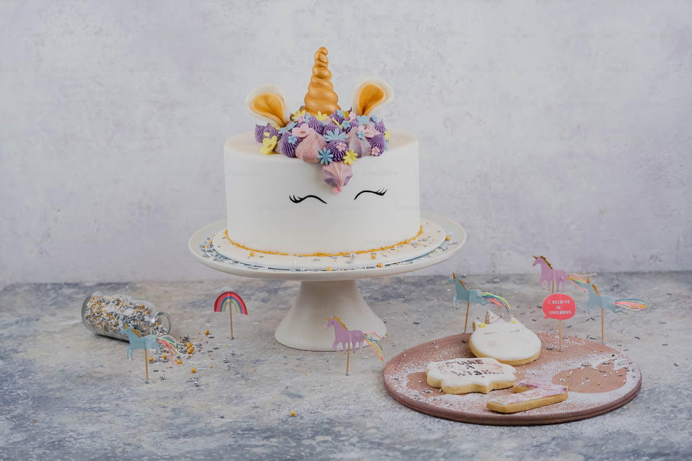 a white cake with a unicorn face on top of it