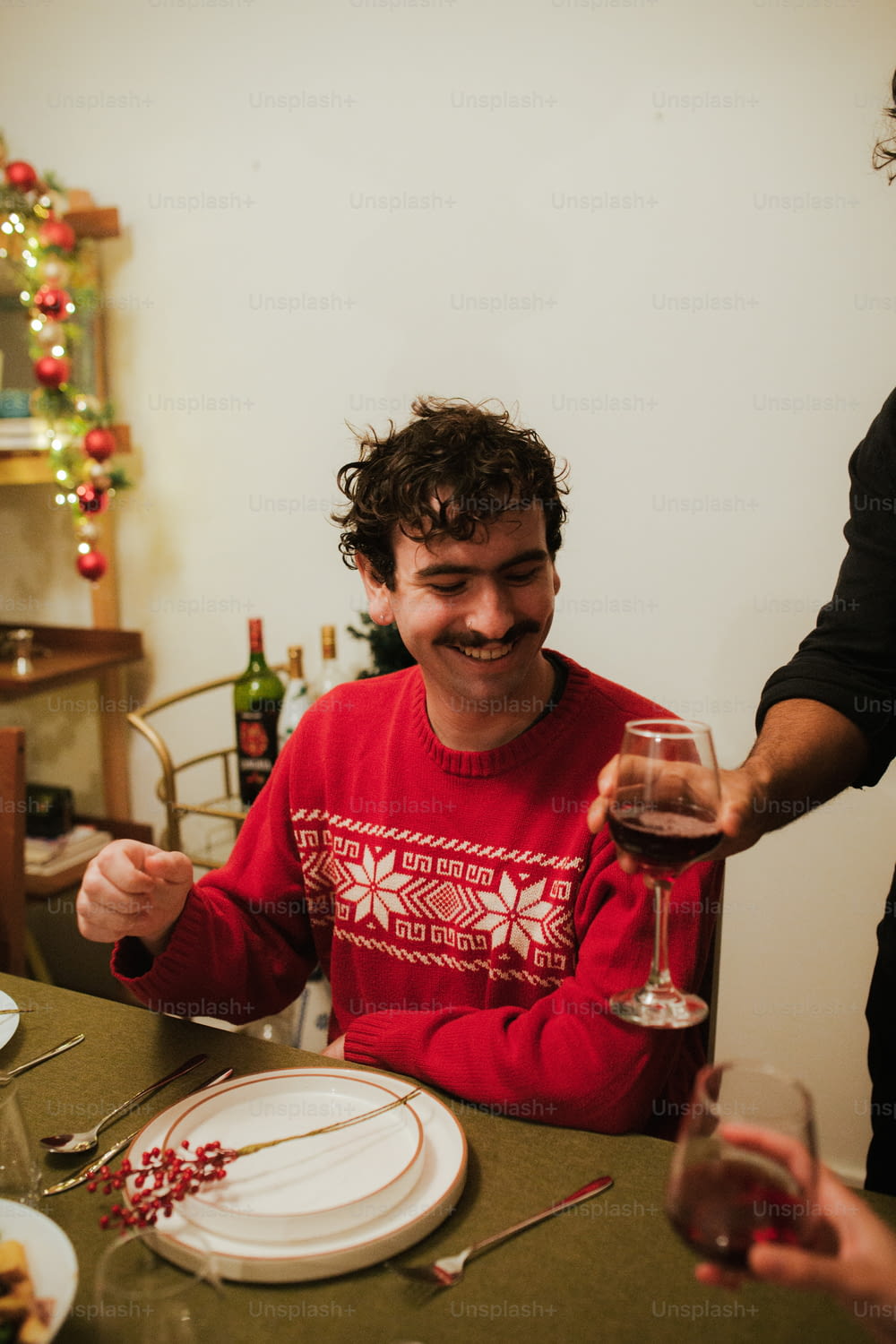 Un hombre sentado en una mesa con una copa de vino