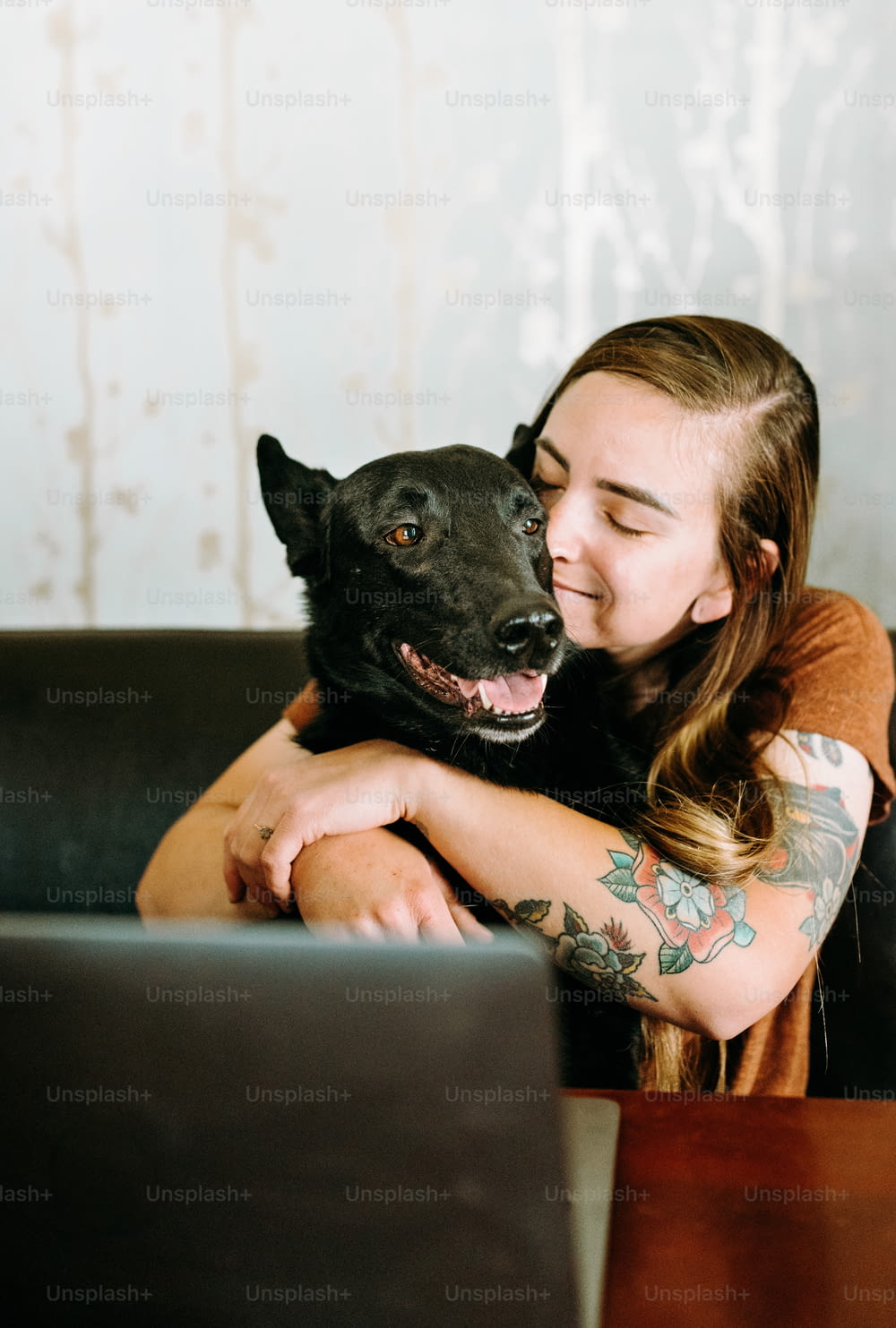 a woman sitting on a couch with her dog