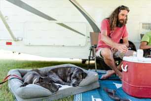 Un uomo seduto accanto a un cane su una coperta