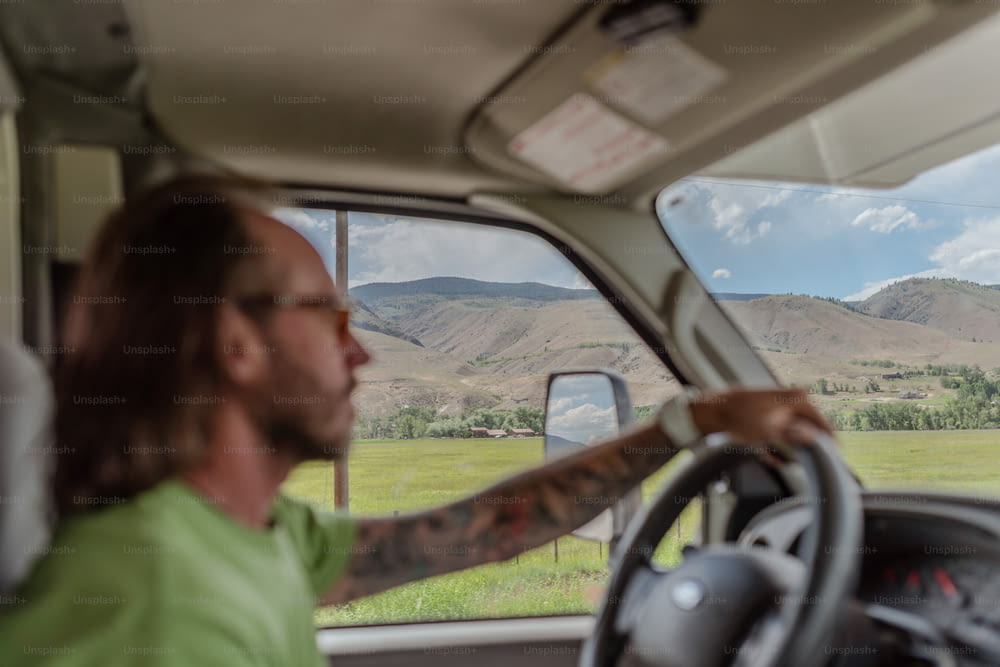 Un uomo alla guida di un camion con le montagne sullo sfondo