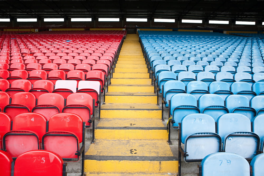 file di sedili blu e rossi in uno stadio