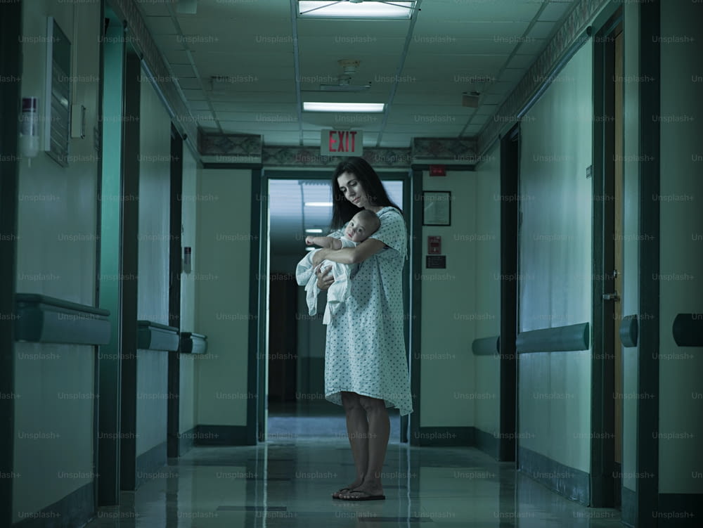una donna in piedi in un corridoio che tiene in braccio un bambino