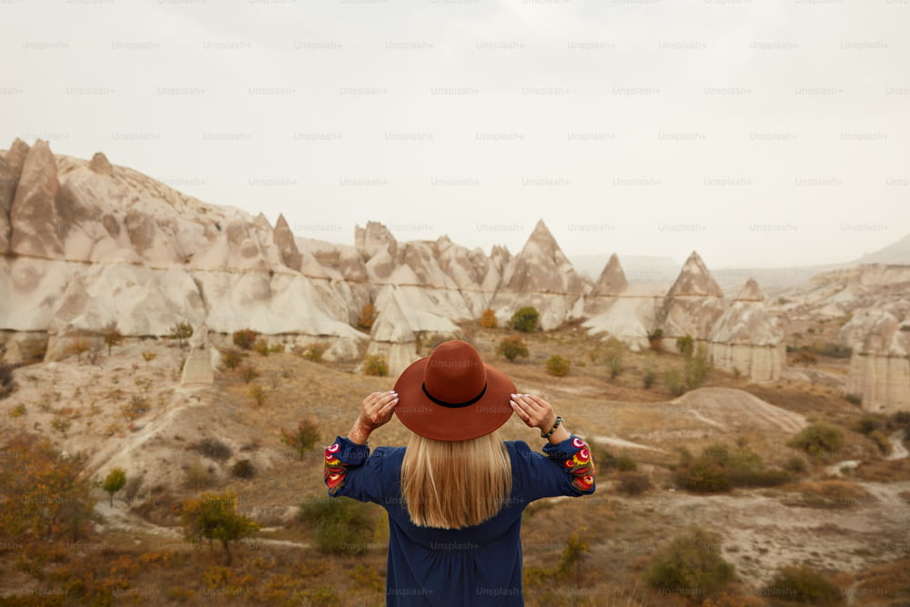 La gente viaja. Hermosa mujer con sombrero que viaja en Rock Valley, explorando el paisaje natural. Alta resolución