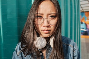 Portrait of an asian girl wearing glasses and looking straight at the camera.