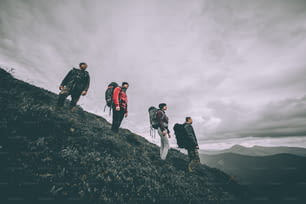 The four people with backpacks standing on the mountain