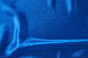 折り目のある青い絹の背景。 波打つサテン表面の抽象的な質感