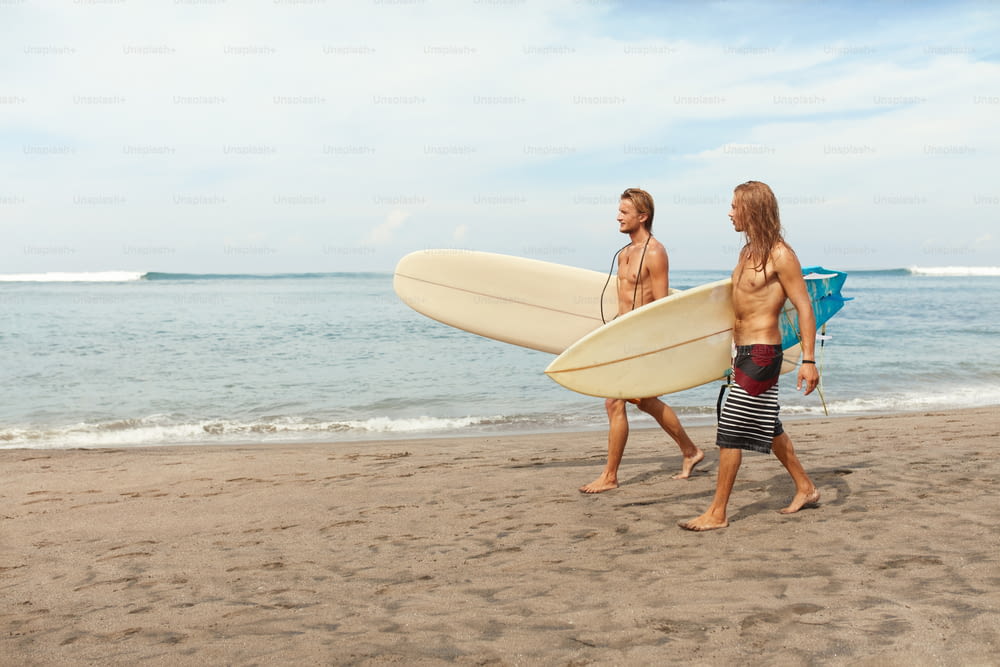 Surfing. Handsome Surfers With Surfboards. Young Men Walking On Sandy Beach. Active Lifestyle, Water Sport On Beautiful Ocean Background.