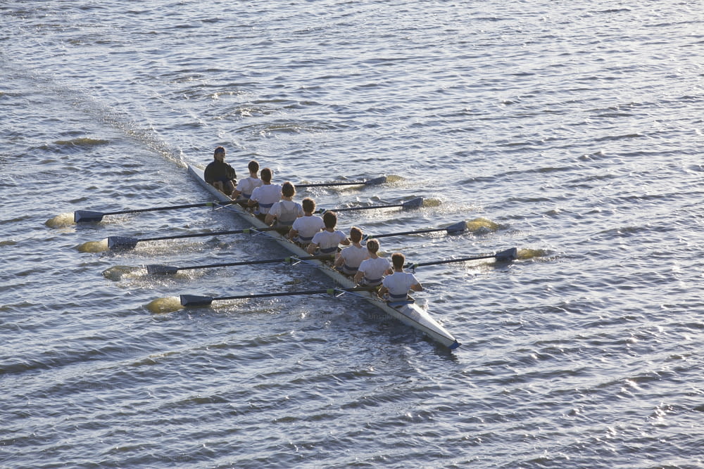 um grupo de pessoas remando um barco em um corpo de água