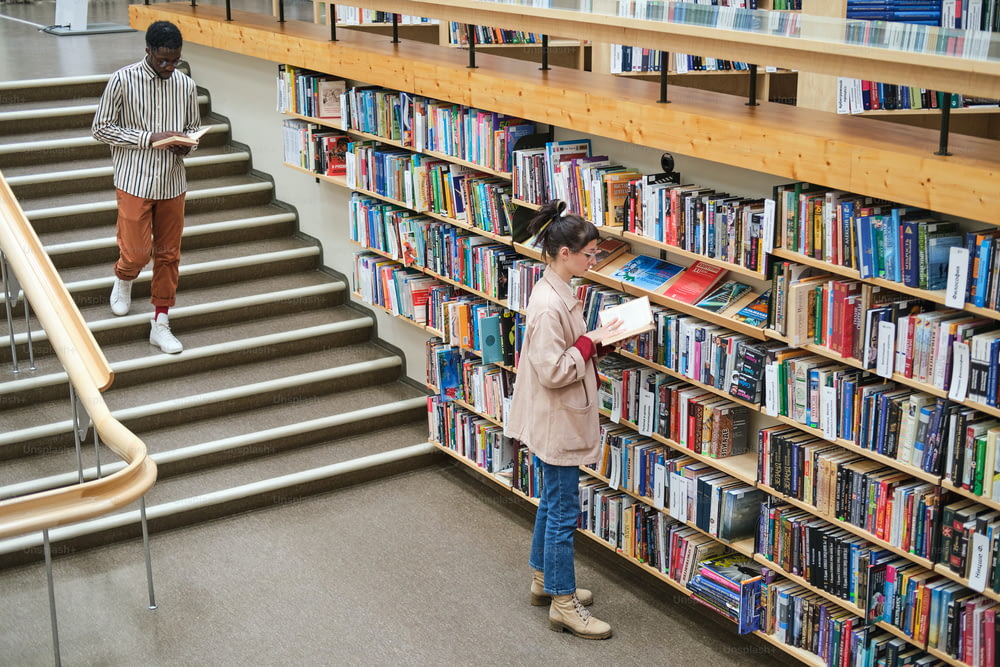 図書館で本を選んで読む若者たち