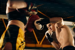 Visão de baixo ângulo de boxeadores que se exercitam durante o treinamento esportivo no clube de boxe.