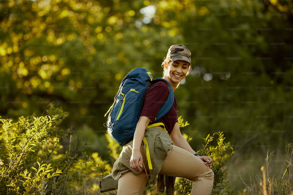 Young happy backpacker spending her day in hiking through nature.