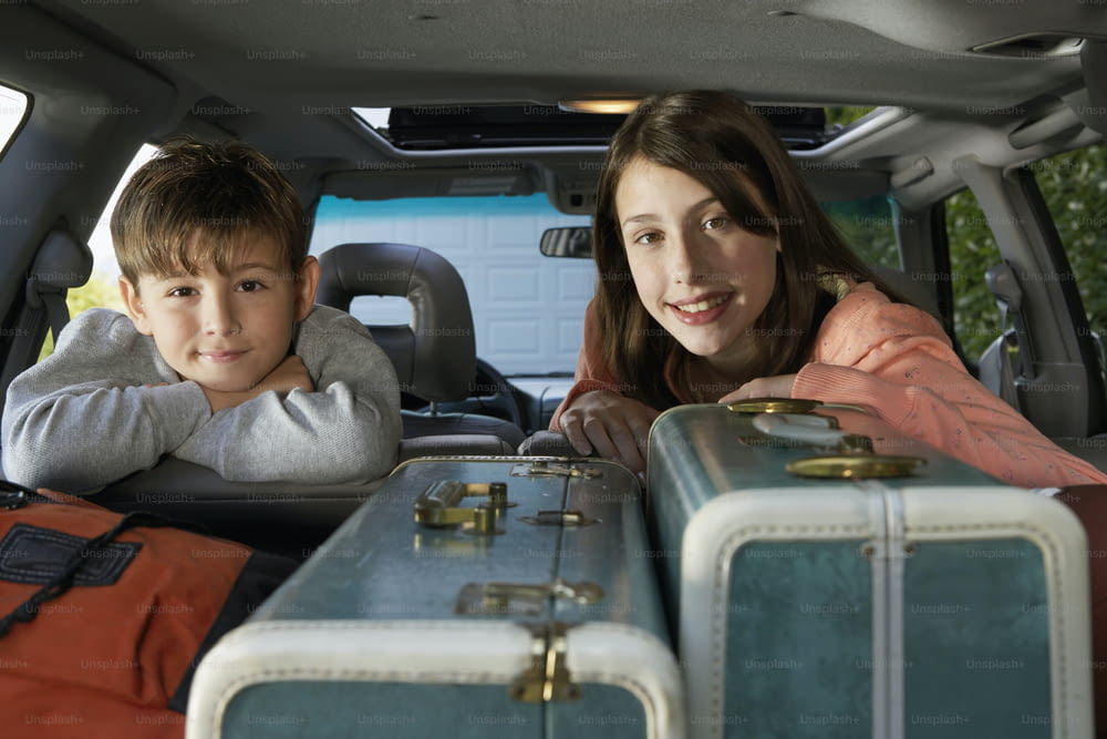 Eine Frau und ein Junge sitzen auf dem Rücksitz eines Autos