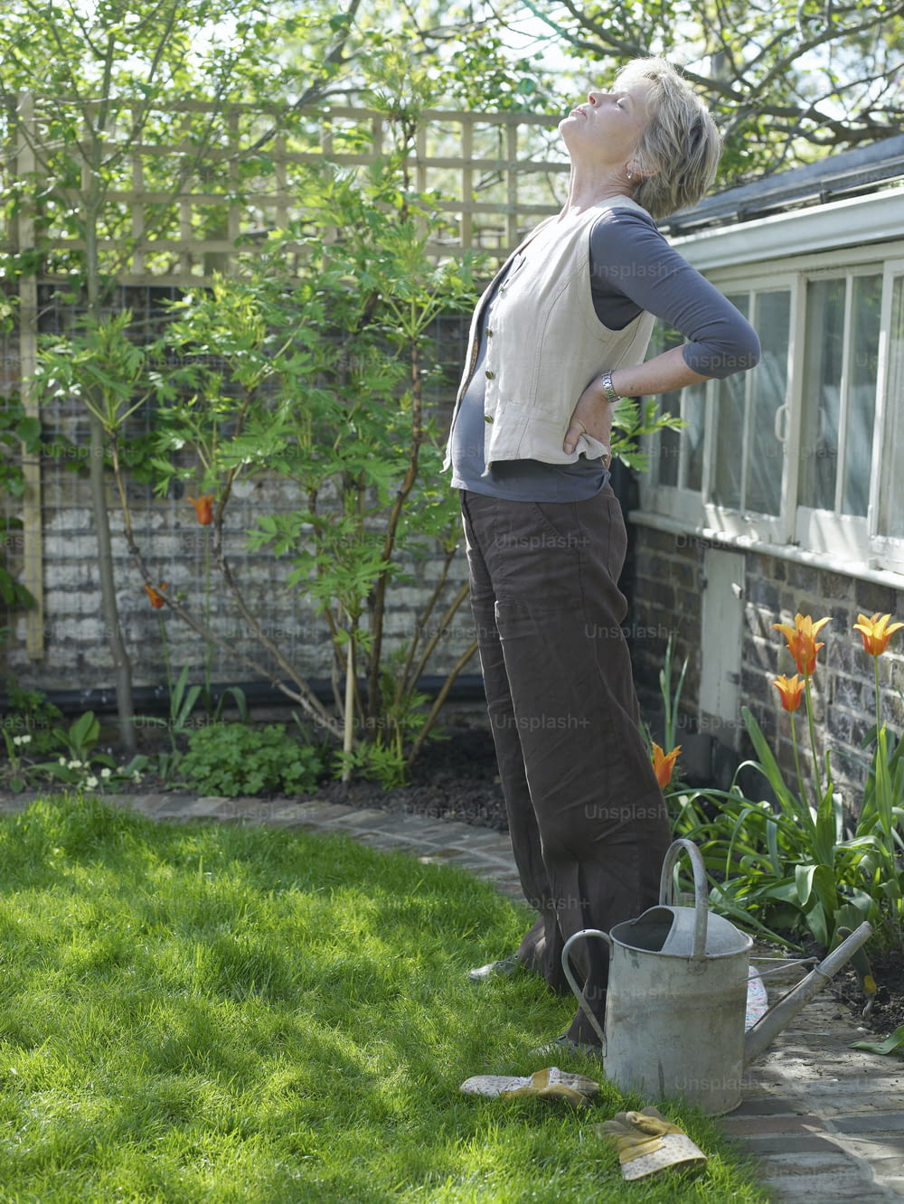 a woman standing in a yard with her back to the camera