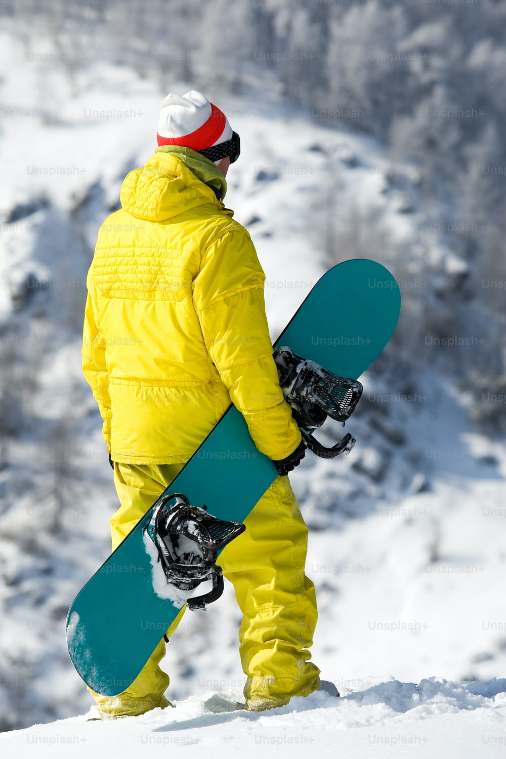 Vista traseira do snowboarder em pé na neve no inverno Nota ao inspetor: a imagem é pré-1 de setembro de 2009