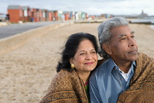 un uomo e una donna seduti su una spiaggia