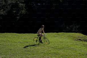 Un hombre montando en bicicleta a través de un exuberante campo verde