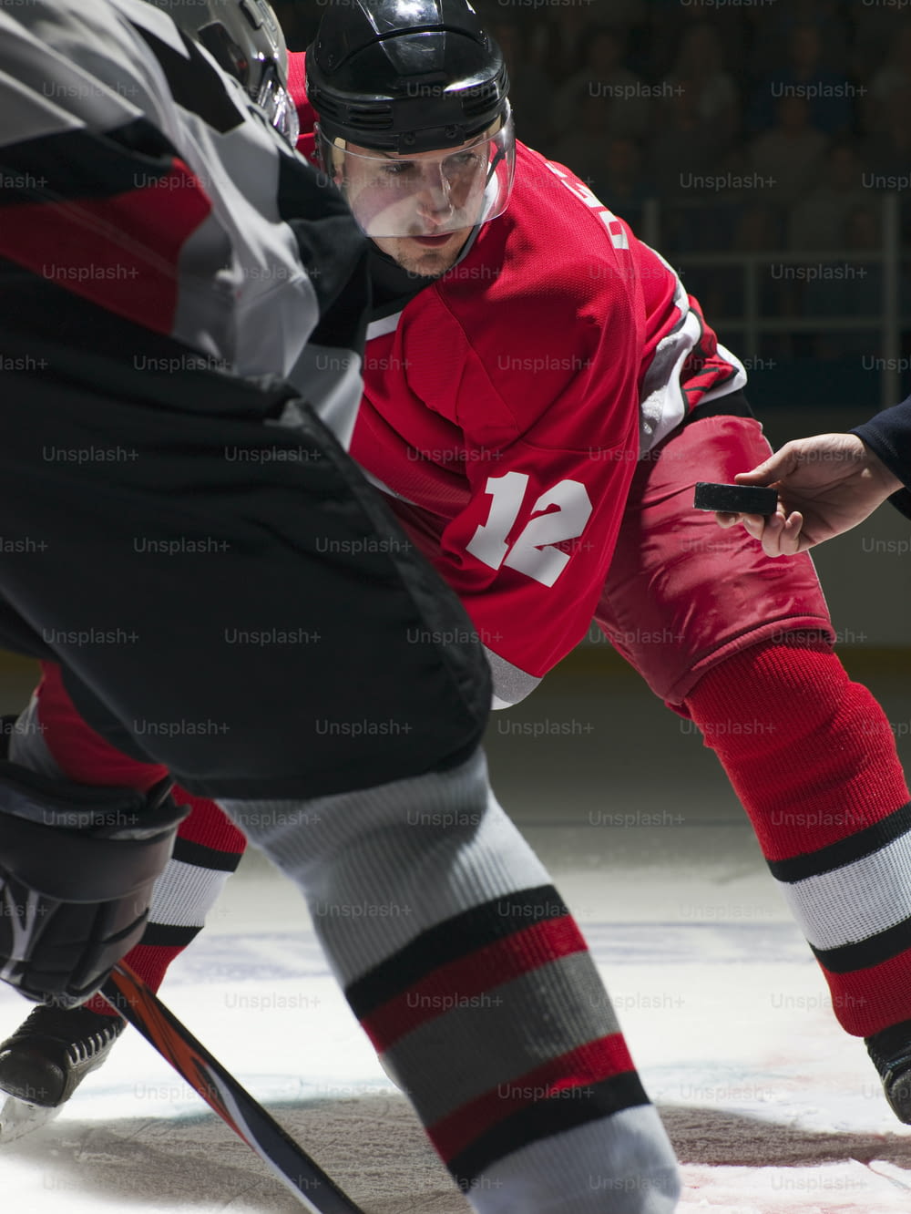 a man in a red jersey is playing ice hockey