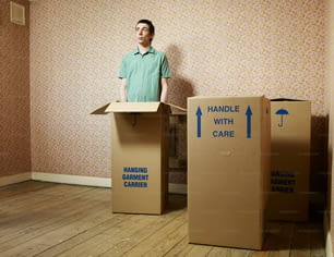 Un uomo in piedi davanti a due scatole di cartone