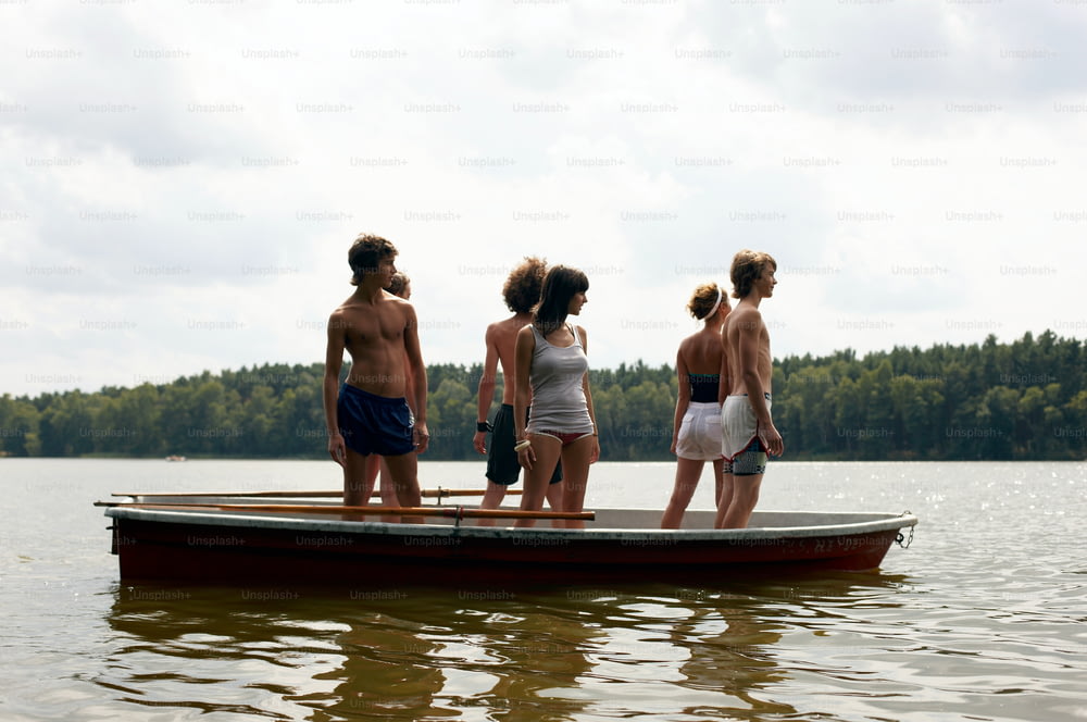 a group of people standing on top of a boat