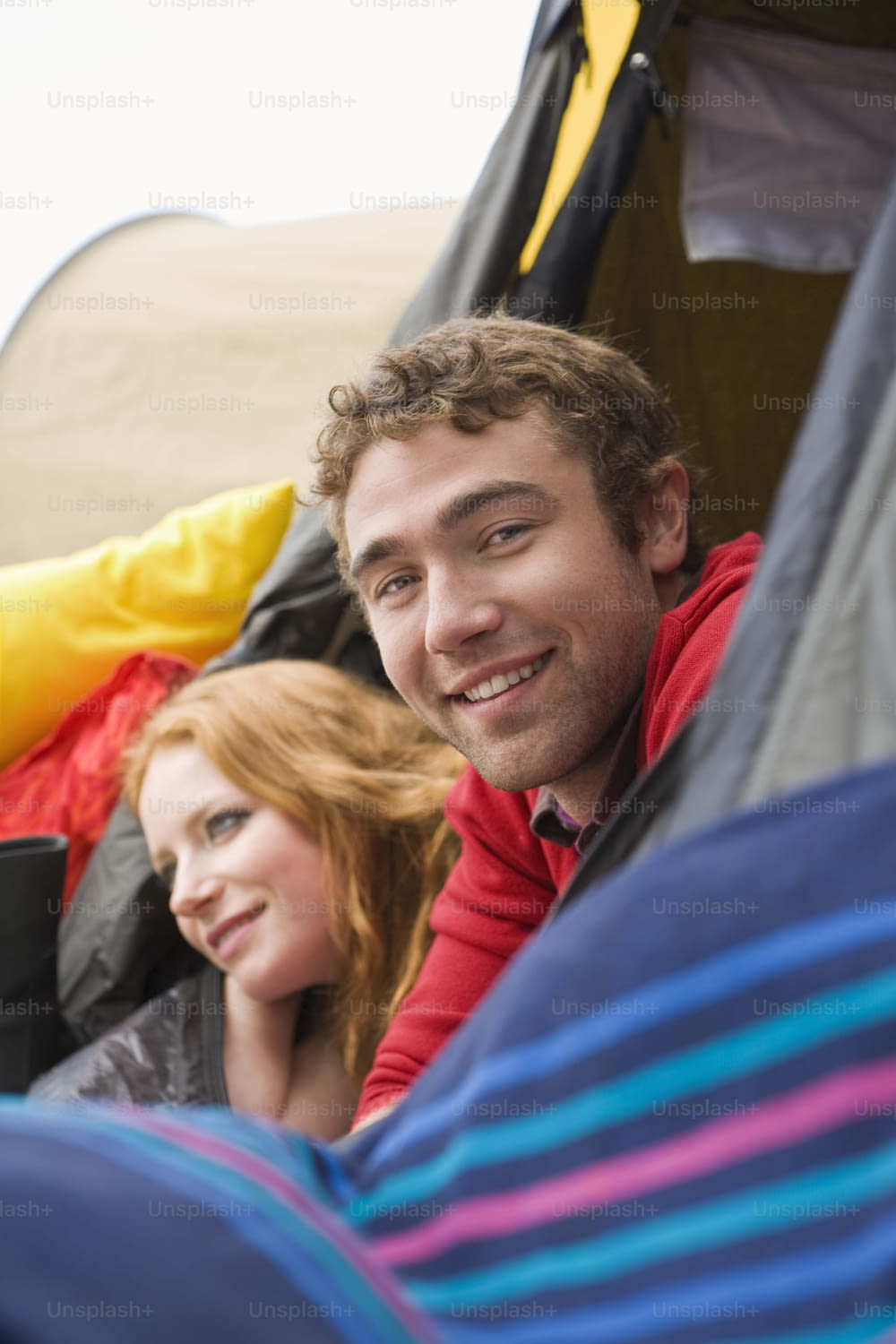 a man and a woman sitting in a tent
