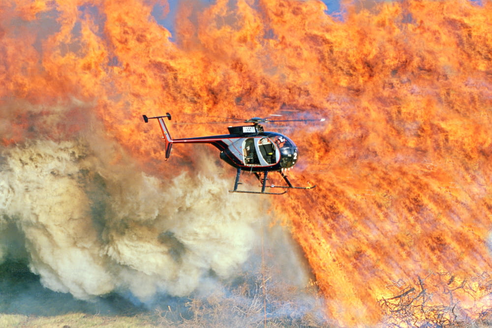 a helicopter is flying over a large fire