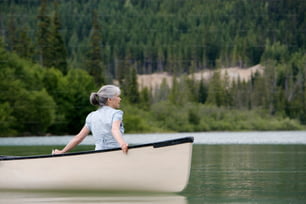 uma mulher sentada em uma canoa em um lago