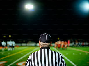 a referee standing on a football field at night