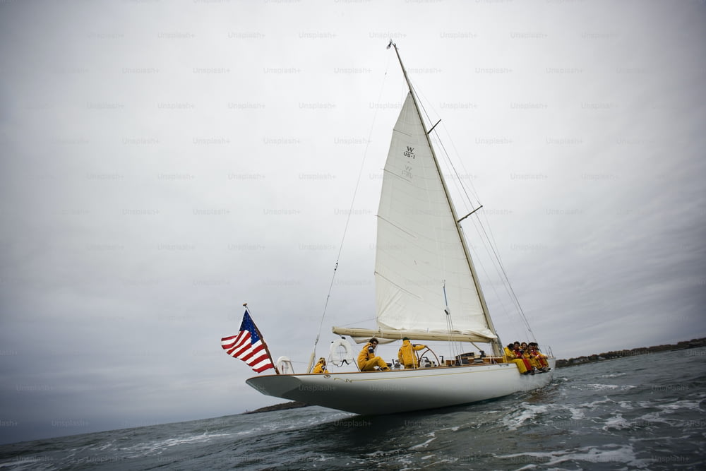 a sailboat with people on it in the water