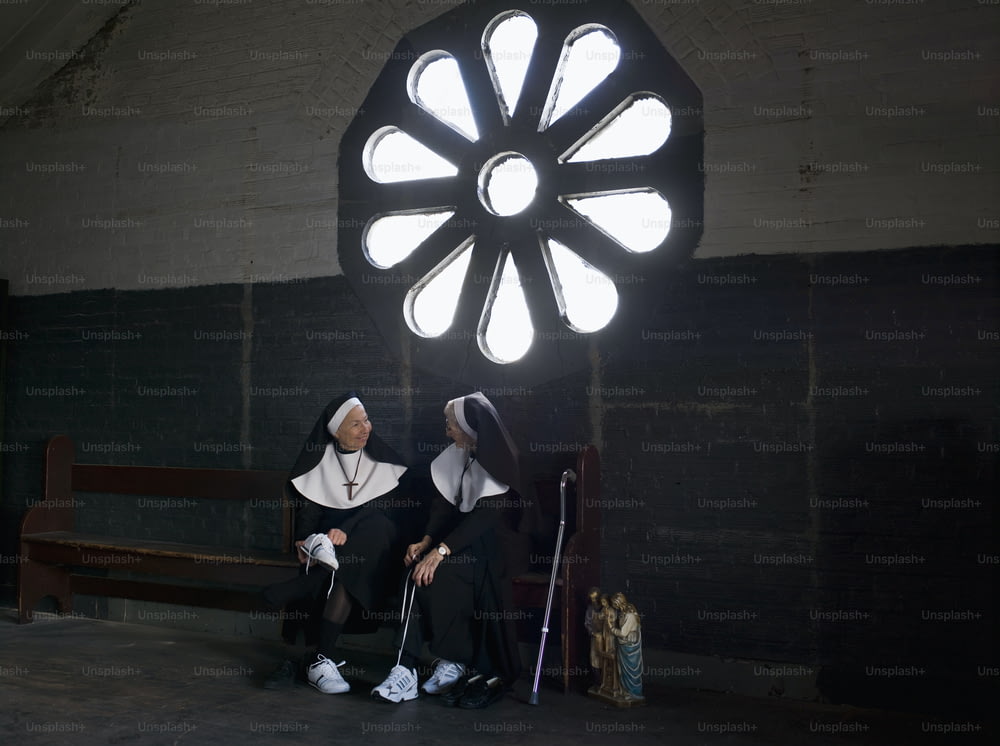 eine Nonne und eine Nonne, die auf einer Bank sitzt
