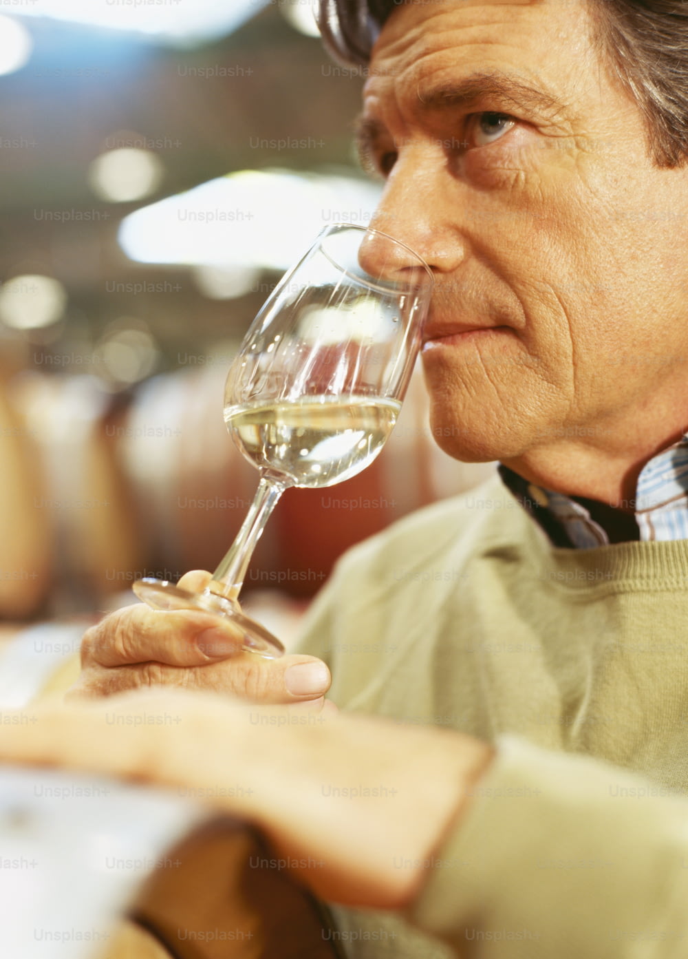 a man drinking a glass of white wine