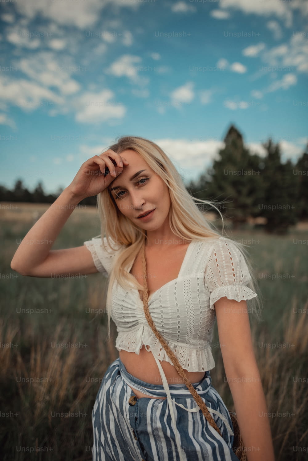 a beautiful blonde woman standing in a field