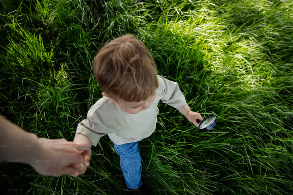 Un petit garçon tenant un téléphone portable dans un champ
