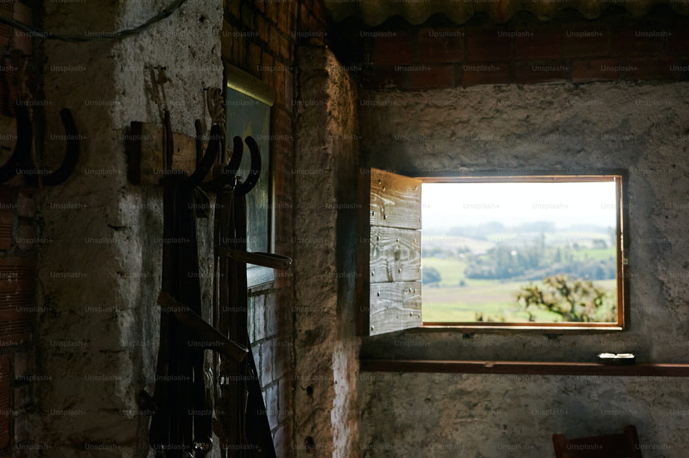 une fenêtre dans un bâtiment en pierre avec vue sur la campagne
