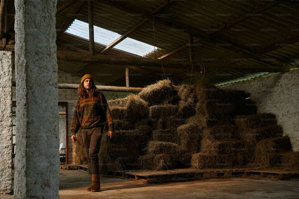 a woman standing in front of a pile of hay