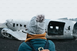 uma pessoa em pé na frente de um avião velho