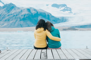 ドックに座って氷河を見ている2人の女性