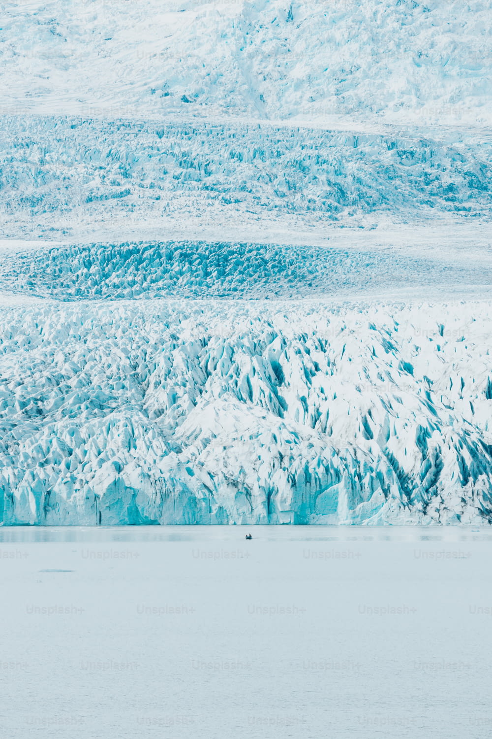 Un groupe de personnes sur un bateau devant un glacier